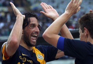 Hellas Verona's Luca Toni, left, celebrates with his teammate Michelangelo Albertazzi after scoring during a Serie A soccer match against AC Milan at the Bentegodi stadium in Verona, Italy, Saturday, Aug. 24, 2013. Luca Toni scored twice and Hellas Verona beat AC Milan 2-1 Saturday to celebrate its return to Serie A after an 11-year absence as the Italian league opened with a shock. After Andrea Poli put Milan ahead in the 14th minute following a pass from Mario Balotelli, the 1.96-meter (6-foot-5) Toni struck back with headers in the 30th and 53rd minutes at the Bentegodi stadium. (AP Photo/Felice Calabro')